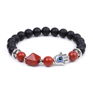 Detail of amethyst pyramid bead with Hamsa Hand and Evil Eye charm on black beaded bracelet