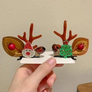 Detail of Christmas reindeer antler hair clips with Santa, berries and tree elements