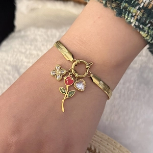 Gold snake chain necklace with butterfly, rose and heart pendants on model wrist