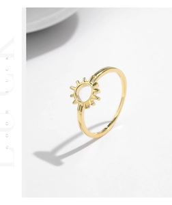 Macro detail of the golden sunburst cutout pattern on a minimalist s925 silver ring