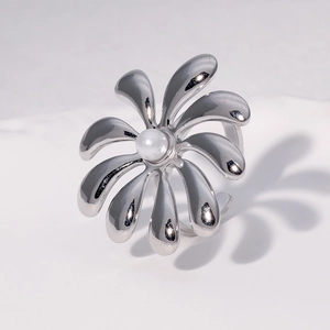 Detailed shot of an adjustable silver flower ring with a central pearl on white background