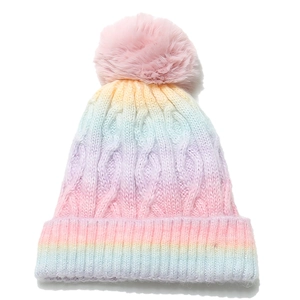 Detail of chunky cable knit texture and soft pom-pom on gradient winter beanie