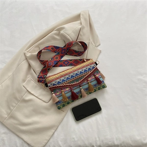 Close-up of bohemian crossbody bag with colorful woven patterns and tassel charms