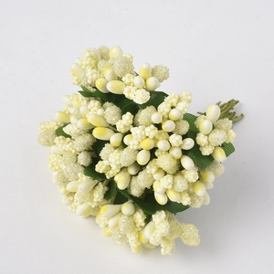 Detailed view of pale yellow artificial berry clusters with green fabric leaves for decor