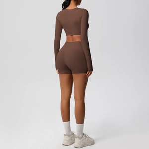 Rear view of brown long sleeve crop top and high waist yoga shorts set on model