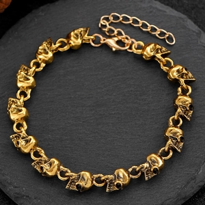 Detailopname van retro gouden schedelarmband op zwarte steen met verstelbare sluiting