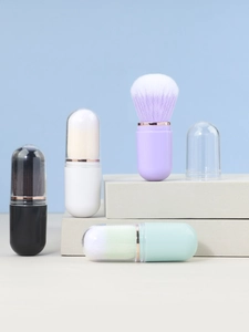 Detail of four colorful capsule-shaped makeup brushes with clear dust covers on steps