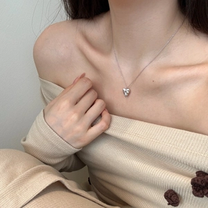 Close-up of S925 sterling silver heart pendant necklace on female model collarbone