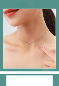 Macro detail of minimalist S925 sterling silver horizontal cross pendant on a model's neck
