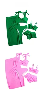 Flat lay of mother-daughter three-piece bikini sets with bows in green and pink colors