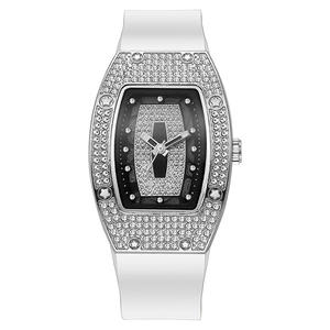 Macro detail of tonneau watch case with pave diamond setting and white silicone strap
