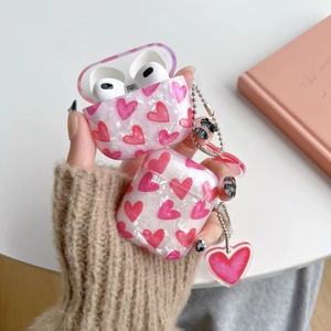 Pink pearlescent AirPods Pro case with heart pattern and beaded heart charm detail