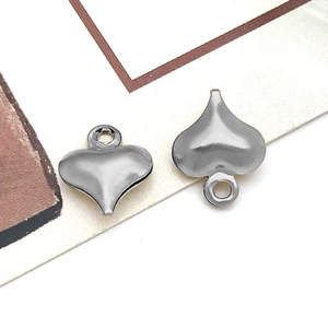Macro shot of two heart-shaped stainless steel pendants with metal hanging loops