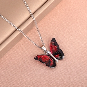 Close-up of butterfly pendant with red-black gradient texture and gold foil accents