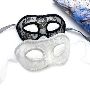 Detail of black and white lace masks showing intricate floral textures and ribbon ties