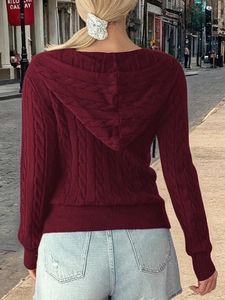 Detail of cable knit texture on deep red hooded sweater with casual street style look