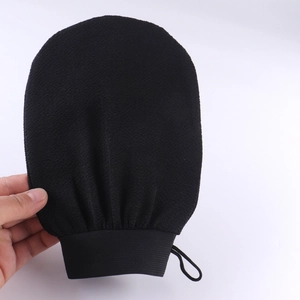 Detail showing the rough texture of a black exfoliating body scrubber glove for skin cleansing