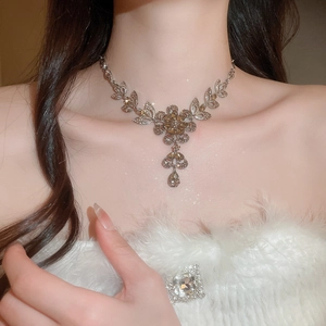 Elegant floral necklace with champagne crystals worn by a model in soft lighting
