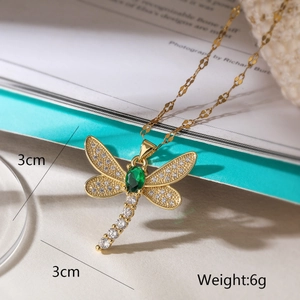 Detail view of gold dragonfly pendant with green gemstone, 3cm size and 6g weight