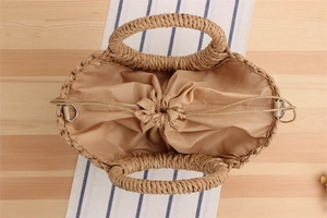 Detail view of woven paper rope beach bag with drawstring liner and round handle