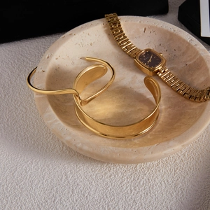 Gros plan sur un bracelet luxe plaqué or 18k en acier inoxydable sur plateau pierre
