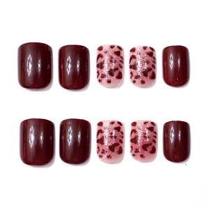 Close-up of wine red and leopard print press-on nails with glitter finish and square shape