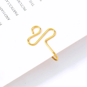 Macro shot of a golden wave-shaped U-ring nose clip attached to a paper edge