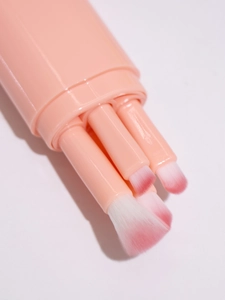 Detail view of 5-in-1 retractable makeup brush with pink soft bristles and storage tube