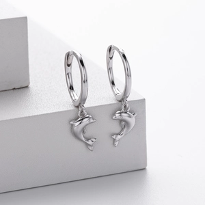 Detailed view of S925 sterling silver dolphin hoop earrings on white display stands