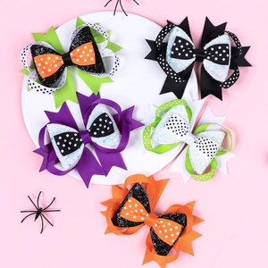 Halloween bow hair clip set with spider patterns and sequins on pink background