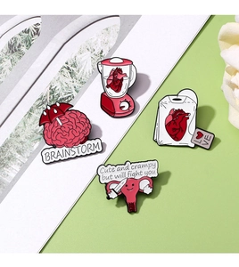 Detailansicht kreativer Emaille-Pins mit anatomischen Organen wie Herz und Gehirn