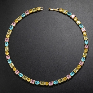 Detailed top view of gold necklace with colorful rectangle and oval cut gemstones