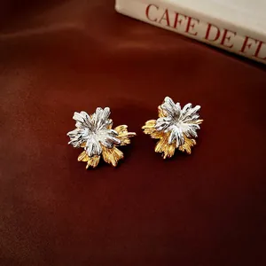 Elegant gold and silver two-tone floral stud earrings with textured metallic petals
