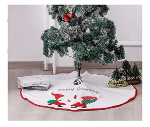 Detailed view of a white Christmas tree skirt with Merry Christmas text and gnome patterns