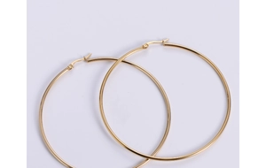 Macro detail of high-polished gold-plated stainless steel large hoop earrings with latch back