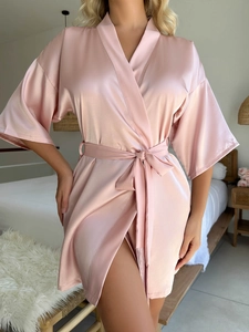 Détail du peignoir en satin rose avec ceinture nouée et texture soyeuse lisse