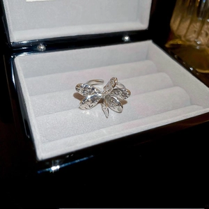 Close-up of a silver butterfly ring with faux pearls in a velvet jewelry box