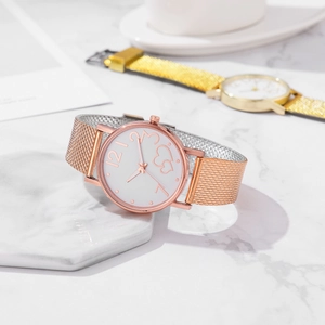 Close-up of rose gold mesh strap women's watch with heart-shaped dial on marble base