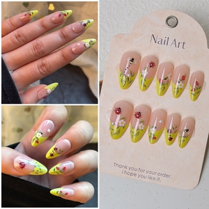 Almond shaped press-on nails with yellow French tips and hand-painted ladybug flower patterns