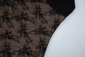Detail of the black floral lace fabric with nude lining and intricate mesh hollow embroidery