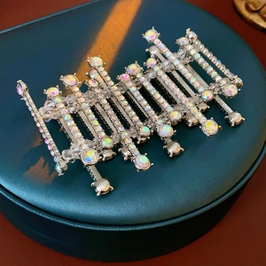 Macro shot of silver barrette with AB rhinestones and pearls on green velvet
