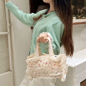 Gros plan détaillé du sac cabas floral en toile avec bordure dentelle et étiquette marque