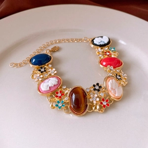 Détail d'un bracelet rétro doré avec pierres multicolores et relief sur plat en céramique