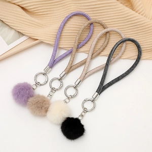 Détail de porte-clés en peluche de lapin en violet, marron, beige et noir