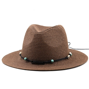 Détail du chapeau Panama marron café avec perles turquoise et garniture en coquillage