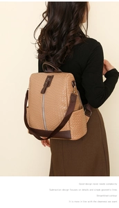 Close-up of brown woven PU leather backpack featuring vertical zip and side pockets