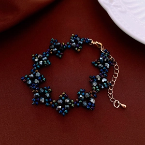 Détail d'un collier de perles fait main avec perles foncées facettées et fermoir doré