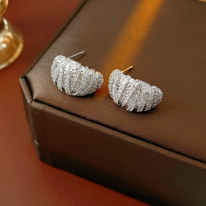 Detailed macro view of silver hoop earrings with pave-set zircon on jewelry box