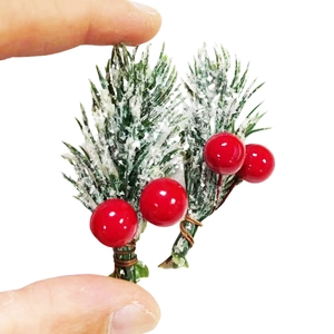 Macro view of mini snowy pine needles with red berries for Christmas DIY decor