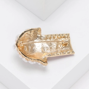 Golden popcorn pin with rhinestones and white pearls shown from the back detail